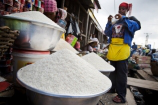 A vendor prepares packs a small portion of rice for a customer at Agbogboloshie food market in Accra, Ghana.