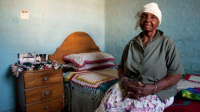 Otilia Tshuma, 71, has been left with two grandchildren to care for in her one room hut