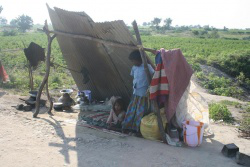 children huddle in makeshift shelter