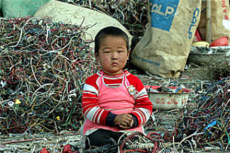  A child at an electronics waste disposal site in Guangdong province, China. Picture: Greenpeace, China