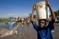 Boy carries water collected  from broken pipe near the JRS Bono Centre; Jimani. Pic: JRS