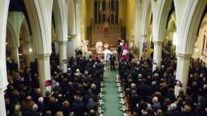 Before the service:  crosses with candles were laid in the aisle of the church for each of the 52 victims.