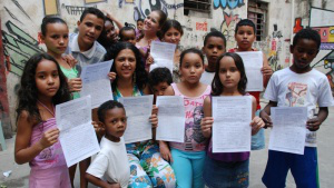 Nete Araujo with children, holding petitions signed by parishioners from England & Wales
