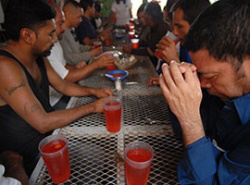 Migrants pray at breakfast