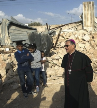 Patriarch views the devastated site