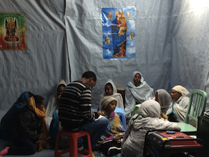 Quiet moment as Eritrean women and children study Bible in camp chapel. Pic ICN