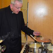 Bishop Lang preparing the meal