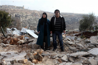 Couple on the site of their demolished home