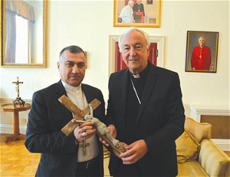 Archbishop Warda and Cardinal Vincent Nichols, holding the crucifix  © ACN