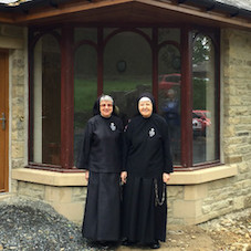 Mother Monica and Mother Regina in front of their new home