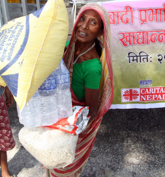 Woman collects a week's food from Caritas Nepal