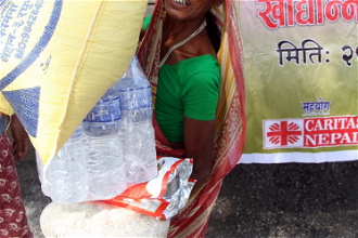 Woman collects a week's food from Caritas Nepal