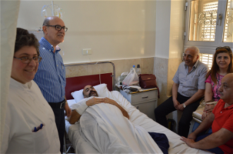 Sister Anne Marie, Dr George Theodory with a patient and family in St Louis Hospital, Aleppo