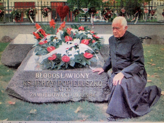 Canon Banaszkiewicz at  grave of Bl Jerzy Popieluszko