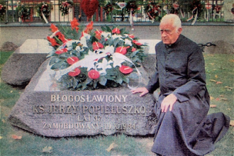 Canon Banaszkiewicz at  grave of Bl Jerzy Popieluszko