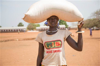 Liapwel carries sack of sorghum from distribution centre in Billing Payam, Yirol East. CAFOD and Trócaire working with Caritas Diocese of Rumbek distributed beans and sorghum to 290 households. Photo: CAFOD/ David Mutua