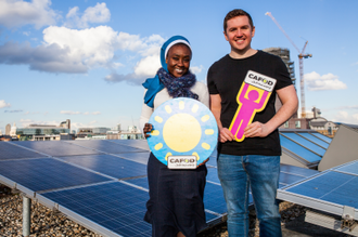 Sr Clara Phiri, Jason Sheehan by solar panels at CAFOD office image: Thom Flint