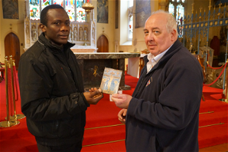 Fr Anthony and Brian Lafferty with damaged icon in front of desecrated altar and sanctuary. Image Keith Morris