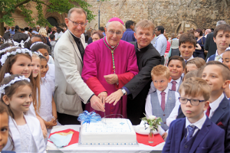 Cathedral Dean Chris Dallison, Bishop Alan Hopes and Fr Adam Sowa cut celebration cake.   Image:  Keith Morris