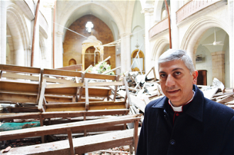 Archbishop Joseph Tobji in  bomb-damaged Maronite Cathedral, Aleppo