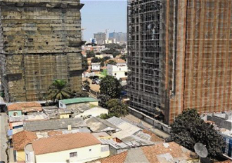 Half-built skyscrapers overshadow Luanda slum