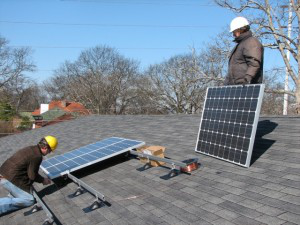 Workers install solar panels on church roof