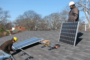 Workers install solar panels on church roof
