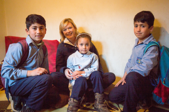 Julie Etchingham with Hussein, 11, left, Amar, 6, middle and Mostafa, 10, right, from Syria, at their home in Qartaba