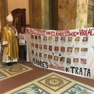 Cardinal with pictures of trafficked children in Buenos Aires Cathedral