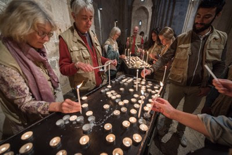 Outgoing EAs light candles before stepping out of Saint Anne's Basilica, ready to head home.