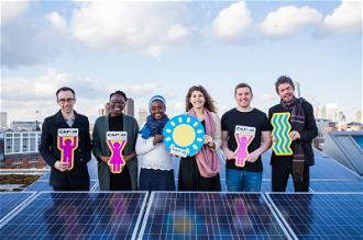 CAFOD staff and volunteers next to solar panels on roof of CAFOD's office. Image: Thom Flint/CAFOD
