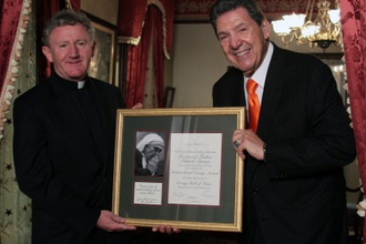 Fr Devine receiving International Caring Award