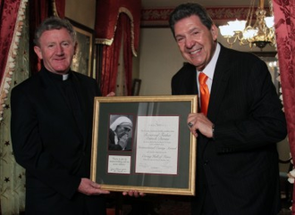 Fr Devine receiving International Caring Award