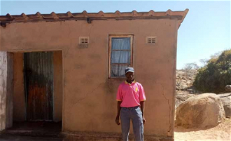 Sekuru stands outside his house which has been cracked since 2014. The house lets in rain but he has received no compensation - Photo Trócaire