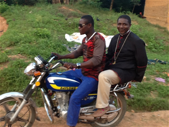 Bishop Andrew Nkea (right) on motorcycle ©ACN