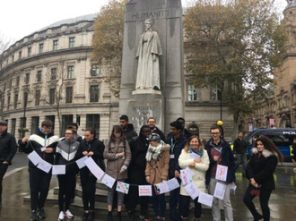 Group with banner at peace statue