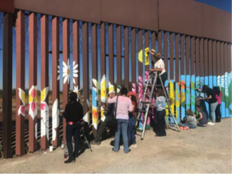 Colourful symbols of hope and resistance being added to south side of wall. Photo: Mike Ferguson