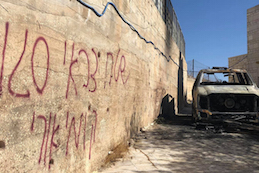 Wall covered in graffiti, car gutted