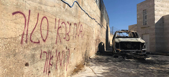 Wall covered in graffiti, car gutted