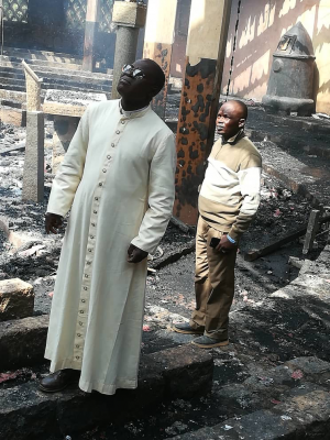 Bishop Bruno Ateba and parishioner inspect Church of St Peter in Douroum, torched in January 2020  - Image: ACN