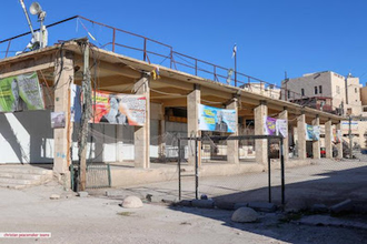 Israeli settler propaganda banners on Palestinian vegetable market stalls in Al Khalil/ Hebron