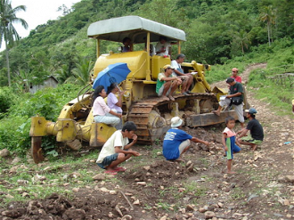 Tribal people in Mindanao, Philippines, sit on drilling equipment to prevent it operating.