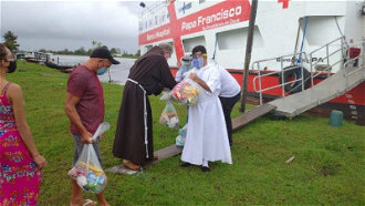 Bishop Bernardo Bahlmann distributes medical supplies from the ship