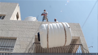 Screenshot: New water tank being hoisted onto roof of family home in Bethlehem