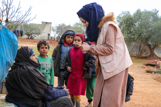 Aid worker talks with Syrian family