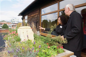 Gail Williams shows Cardinal the garden project
