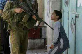 Israeli solder interrogates small boy while settlers take Palestinian land unhindered