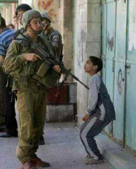 Israeli solder interrogates small boy while settlers take Palestinian land unhindered
