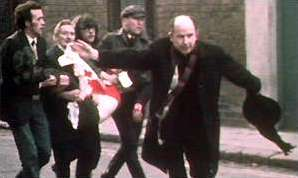 Fr Edward Daly waving blood-stained handkerchief as he escorts mortally-wounded boy to safety on Bloody Sunday.  image by BBC journalist John Bierman. Wiki Image