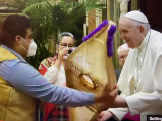 A member of the Assembly of First Nations delegation presents Pope Francis with snowshoes made from ashwood by elders from the Cree community in Quebec